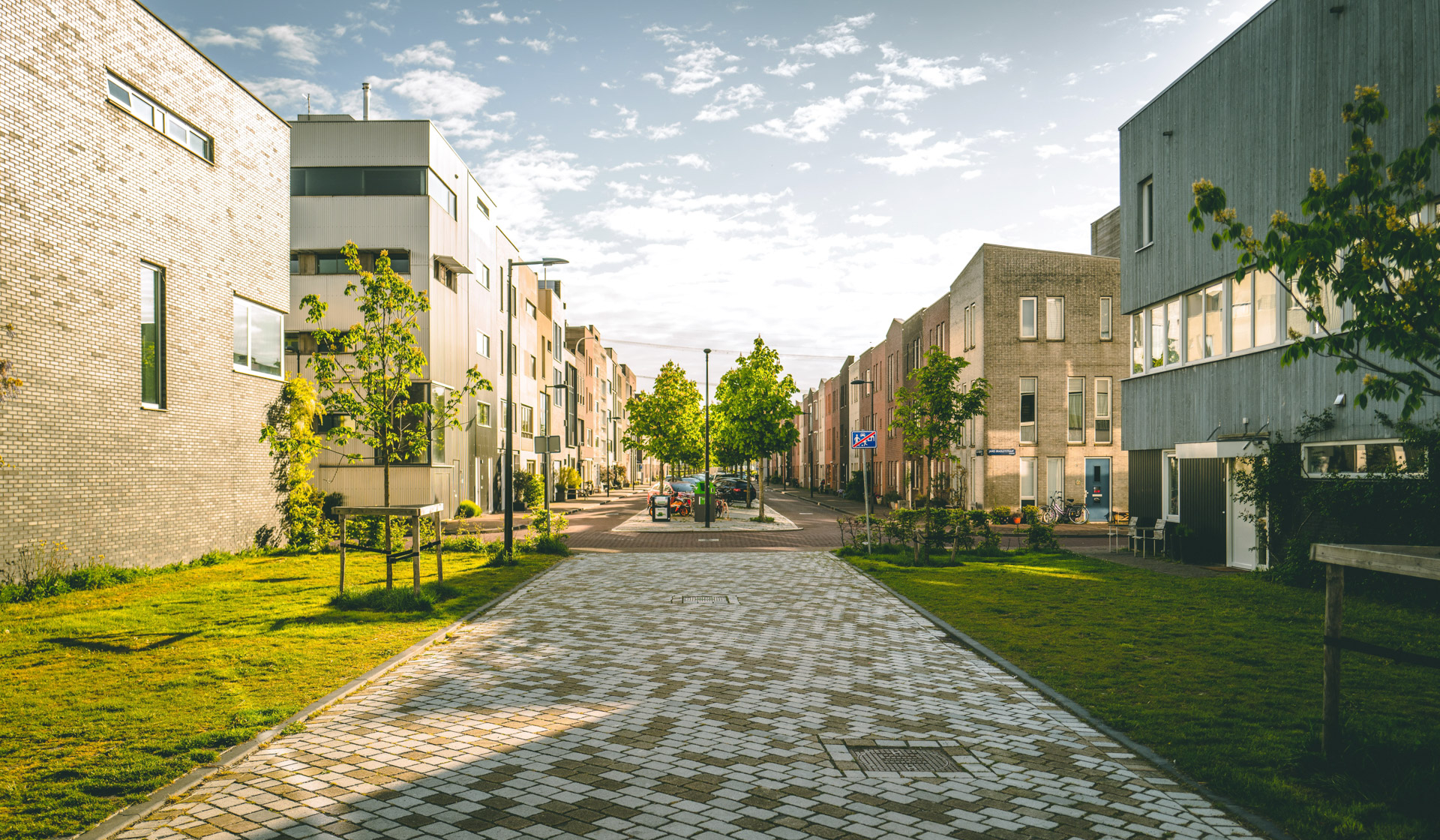 Modern urban streetscape with mixed-use buildings, green corridors and pedestrian paths